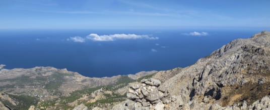 Behind the rocky promontory of the summit of Kali Limni, the bright blue sea of the west side of