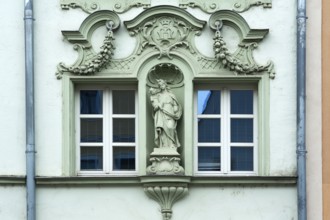Window framed with figures of saints on a historic façade from 1895, of a former liqueur