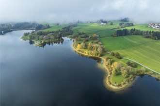 Sports facility and bathing area, lake Rottachsee, shore covered with fog, autumn, aerial view,