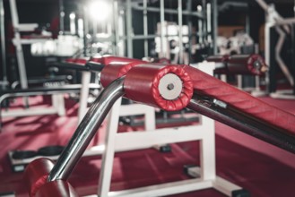 Picture of a modern fitness studio with various training equipment in red and steel, historic