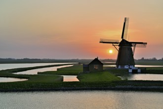 Historic windmill in the light of the setting sun, De Traanroeier, Het Noorden Molen, Texel, North