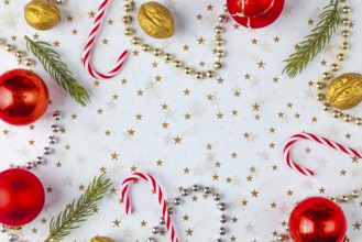 Frame made of Christmas decorations, fir branches, baubles, nuts on a white background with golden