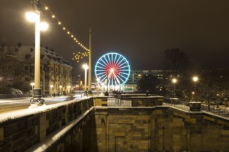 Christmas illumination on the Augustus Bridge in the snow with log cabin, Ferris wheel and steps,