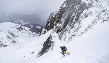Ski tourer on a steep mountain slope, Snowy mountain landscape, Bernese Alps, Bernese Oberland,