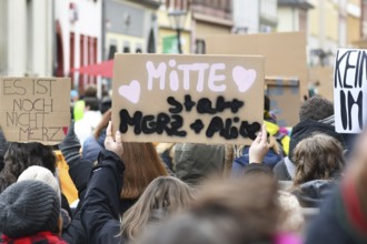 Heidelberg, Germany - February 12th 2025: Person holding up sign saying 'Middle insteaf of Merz and