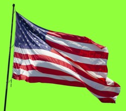 American flag waving in the wind on a flag pole over a green screen