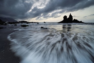 Dramatic clouds with rock formation at rising tide at the beach of Playa de Benijo, Tenerife,