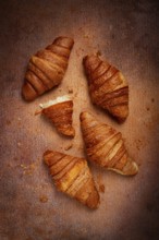 Fresh croissants, breakfast, top view, on the table, brown background, no people