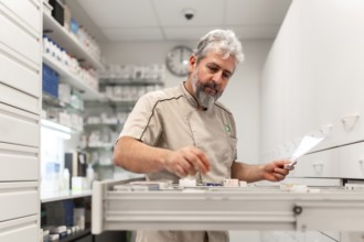 Pharmacist checking medicines on rack. Chemist searching the medicines at storage self