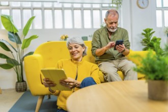 Senior couple using diverse devices and technology together at home