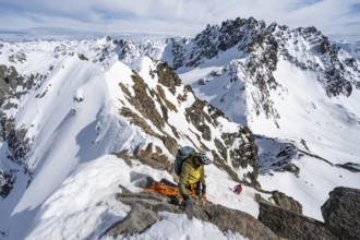 Mountaineer belaying on a steep snow slope, belaying on a rope, ascent to the summit of Piz