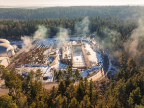 Snow-covered building site next to domed buildings, surrounded by forest, new fire station,