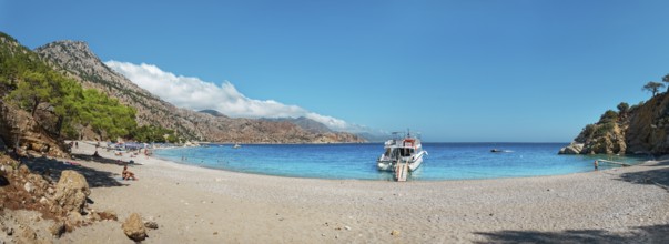 Coastal scene with a boat on Apella beach and blue sky, Apella beach, Karpathos, Greece, Europe