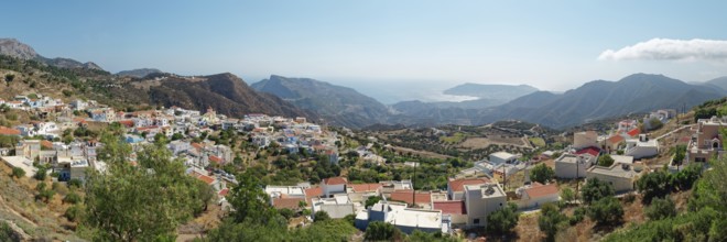 Panoramic view of the village of Othos, mountains and sea under a blue sky, hike from Pyles to