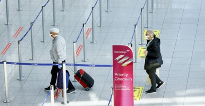 Passengers wearing face masks at the Eurowings check-in counter at Düsseldorf Airport during the