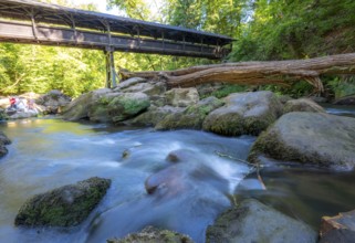 The Irrel Waterfalls, rapids in the lower reaches of the Prüm, covered wooden bridge for hikers,