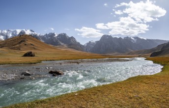 Mountain landscape with yellow meadows and river Kol Suu, mountain peak with glacier, hike to the