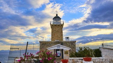 An old lighthouse overlooked by a dramatic sky at sunset, surrounded by flowers, lighthouse, Cape