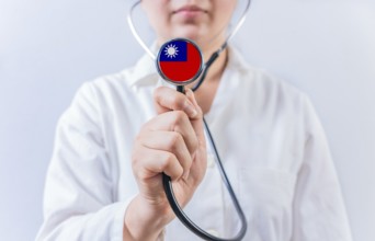 Female doctor holding stethoscope with Taiwan flag. National health system of Taiwan