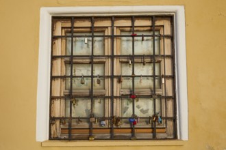 A shuttered window with bars in a yellow wall, harbour area, Rhodes Town, Rhodes, Dodecanese, Greek