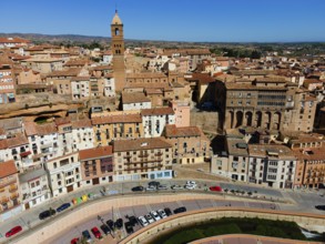 Aerial view of a historic city with a striking tower and many tiled roofs, aerial view, church,
