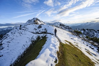 Mountaineer on hiking trail, mountain landscape with snow in autumn, summit and ridge of the