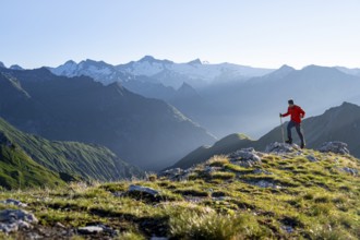 Hiker enjoying the mountain panorama in the morning, Venediger group, behind Dreiherrenkopf,