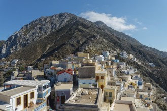 Colourful houses of the picturesque village of Olymbos spread out on a mountainside under a clear