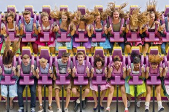 Boys and girls swinging with blowing hair in giant swing Top Spin Fresh, swing, ride on the Wies'n,