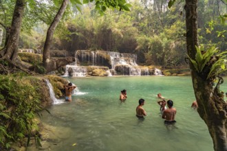 Tourists bathing in the Kuang Si waterfall near Luang Prabang, Laos, Asia