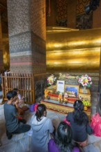 The reclining Buddha with praying believers in Wat Pho temple, Buddhism, religion, world religion,