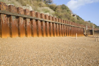 Rusty steel piling sea wall defences and shingle beach near Bawdsey Quay, Suffolk, England, United