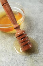 Wooden spoon with honey, on the table, spindle for honey, mace, close-up, rustic