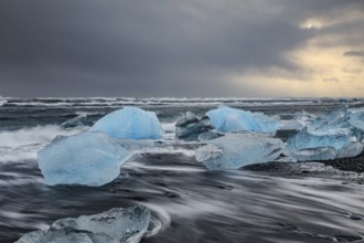 Ice floes on the beach, waves, sea, clouds, sunlight, winter, Diamond Beach, Breidamerkursandur,