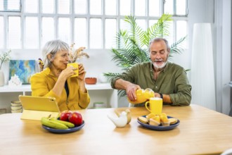 Frontal view of a caucasian mature couple having pleasant healthy breakfast together