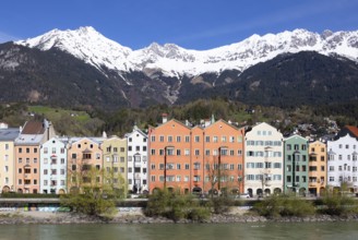 Colourful buildings along the Inn river with snow-covered Nordkette in the background, Karwendel