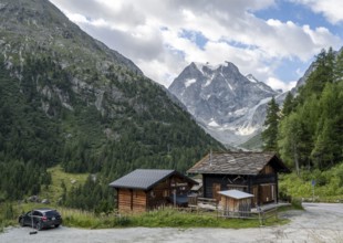 Wooden houses in the mountain village of Arolla, behind mountain peak Mont Collon, Valais, Western