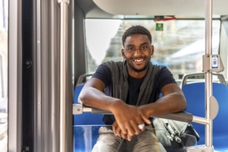 Portrait of a happy african man sitting on the public bus on the way to work