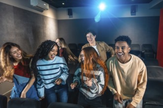 Happy multi ethnic friends dancing and celebrating together at a lively movie disco event in the