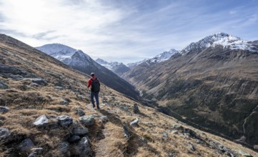 Mountaineers on a hiking trail, view over the Niedertal valley with snow-covered mountain peaks of