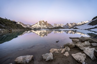Evening mood with pink evening sky, mountain landscape with mountain hut Refuge du Lac Blanc at