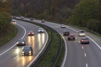 Traffic on a wet motorway at dusk, surrounded by trees, Rems-Murr district, Baden-Württemberg,