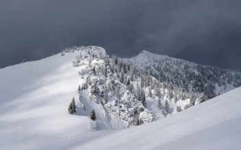 Mountain landscape in the snow, mountain peaks Tanzeck and Aiplspitz, dramatic clouds,