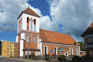 Historic church with brick tower in front of cloudy sky in city neighbourhood, Dominikuskirche,