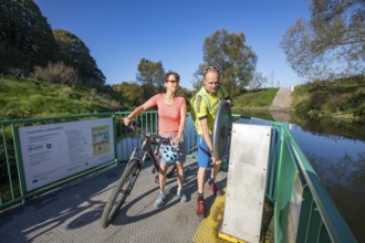 Cyclist, cycle tour, manually operated ferry across the Lippe near Halten am See, on the
