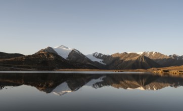 Glaciated mountain peaks reflected in a mountain lake at sunset, Arabel Lake at Arabel Pass, Issyk