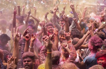 Revellers dancing in the beat of music as they celebrate Holi on a street, the Hindu spring
