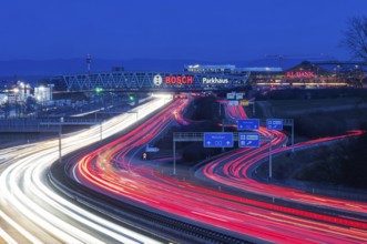A8 motorway at Stuttgart Airport in the evening. Heavy traffic, lanes of light. Modern architecture