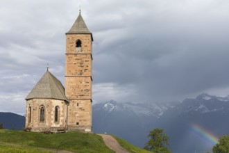 Church St. Kathrein, 39010 Hafling, Italy with a rainbow in the background. The church is from the