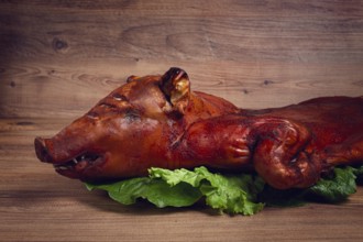 Baked, fried piglet, on a wooden table, no people, The whole piglet is baked and served on the